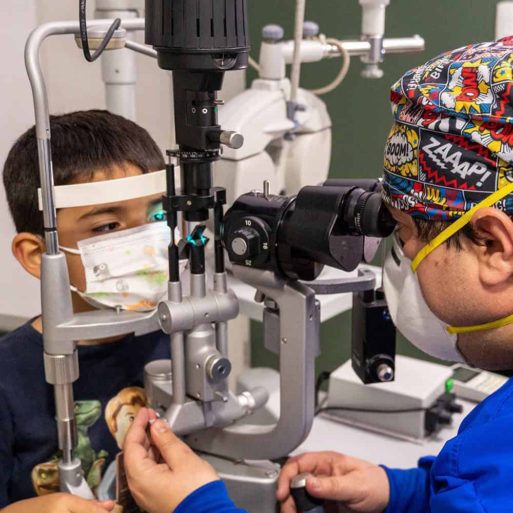 Niño en evaluación oftalmológica pediátrica con lámpara de hendidura