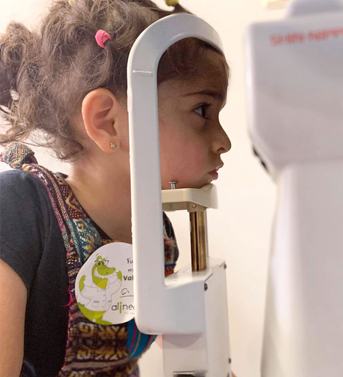 Niña durante un examen visual en el equipo de diagnóstico de la clínica